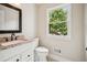 Well-lit bathroom featuring granite countertops, a modern faucet, and a window with a tree view at 2907 Wickford Dr, Kennesaw, GA 30152