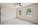 Bright bedroom featuring neutral walls, soft gray carpet, ceiling fan, and windows providing natural light at 2907 Wickford Dr, Kennesaw, GA 30152