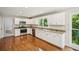 A modern kitchen offers white cabinetry, granite countertops, and stainless-steel appliances with hardwood floors at 2907 Wickford Dr, Kennesaw, GA 30152