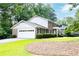 A two-story brick home with a large garage, lush landscaping, and an open front lawn at 5287 Vernon Lake Dr, Atlanta, GA 30338