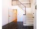 Home foyer featuring black tile floors, staircase with white banister, and open doorway at 5287 Vernon Lake Dr, Atlanta, GA 30338