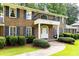 A stately two-story brick home featuring blue shutters, a balcony, and manicured landscaping at 5287 Vernon Lake Dr, Atlanta, GA 30338