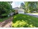 View of the property's two-car garage with an extra-long driveway on a sloping lawn at 5287 Vernon Lake Dr, Atlanta, GA 30338