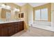 Bathroom with double vanity, soaking tub, and natural light, creating a relaxing space at 12290 Greenmont Walk, Alpharetta, GA 30009