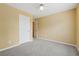 Bedroom with neutral carpet and paint and view of closet and ceiling fan at 12290 Greenmont Walk, Alpharetta, GA 30009