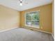 Bright bedroom featuring neutral carpet, a ceiling fan, and natural light from the large window at 12290 Greenmont Walk, Alpharetta, GA 30009