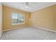 Bedroom featuring neutral carpet, a ceiling fan, and natural light from the large window at 12290 Greenmont Walk, Alpharetta, GA 30009