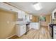 Open concept kitchen featuring white cabinets, stainless appliances, stone countertops, and hardwood floors at 12290 Greenmont Walk, Alpharetta, GA 30009