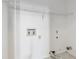 This is a white utility room showing hook ups, wall shelving, and tiling at 12290 Greenmont Walk, Alpharetta, GA 30009