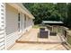 Enjoy outdoor relaxation on this wooden back deck with stylish furniture and a lush view of trees at 3129 Etchison Rd, Loganville, GA 30052