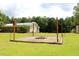 Large backyard with outdoor fireplace and home with metal roof in the background at 3129 Etchison Rd, Loganville, GA 30052