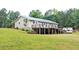 Expansive backyard view highlighting the home's back elevation, deck, and lush greenery at 3129 Etchison Rd, Loganville, GA 30052