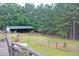 View of the fenced in acreage with barn and wooded area at 3129 Etchison Rd, Loganville, GA 30052