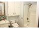 Cozy bathroom featuring a shower-tub combo, decorative tile backsplash, and storage cabinets at 3129 Etchison Rd, Loganville, GA 30052