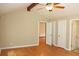 Bedroom with hardwood floors, ceiling fan, and multiple doors leading to other rooms and closets at 3129 Etchison Rd, Loganville, GA 30052
