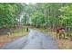 Curving paved driveway with mature trees on either side, alongside fencing and a rural-style mailbox stand at 3129 Etchison Rd, Loganville, GA 30052