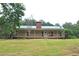 Charming single-story home featuring a covered porch and green metal roof at 3129 Etchison Rd, Loganville, GA 30052