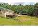 The house features a deck, lush yard, and wooded surroundings at 3129 Etchison Rd, Loganville, GA 30052