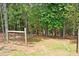View of the property line, with wooden fence posts and wire fencing surrounded by mature trees and natural landscape at 3129 Etchison Rd, Loganville, GA 30052