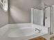 Bathroom featuring a luxurious tub with a glass enclosed shower at 3202 Ivy Station Way, Duluth, GA 30096