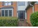 View of front door with decorative glass sidelights and brick walkway and manicured bushes at 3202 Ivy Station Way, Duluth, GA 30096
