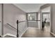 Bright hallway with railing and view of a room with a desk, chair and windows at 3202 Ivy Station Way, Duluth, GA 30096