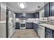 Well-lit kitchen featuring stainless steel appliances, dark cabinets, and mosaic backsplash at 3202 Ivy Station Way, Duluth, GA 30096
