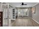 Open living room with hardwood floors, a ceiling fan, and a view into the entry through glass doors at 3202 Ivy Station Way, Duluth, GA 30096