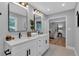 Bright bathroom featuring double vanity, white cabinets, modern fixtures, and an open view to a well lit bedroom at 4492 Riverwood Cir, Decatur, GA 30035
