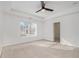 Carpeted bedroom featuring tray ceilings, a ceiling fan, and natural light from large window at 55 Bowen Ave, Atlanta, GA 30315