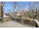 This wooden deck has wooden floors, black iron railings, and a view of the neighborhood and trees at 55 Bowen Ave, Atlanta, GA 30315