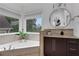 Serene bathroom features a large corner tub with views, a vanity, and neutral decor at 13 Highland Park Ne Ln, Atlanta, GA 30306