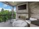 Cozy covered deck features a stone fireplace, mounted TV, and comfortable seating at 13 Highland Park Ne Ln, Atlanta, GA 30306