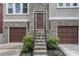 Inviting front entrance with stone steps, wrought iron railings, and double garage doors at 13 Highland Park Ne Ln, Atlanta, GA 30306