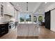 Modern kitchen featuring a marble island, stainless steel appliances, and abundant natural light from large windows at 13 Highland Park Ne Ln, Atlanta, GA 30306