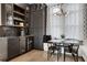 Stylish wet bar with dark cabinetry, wine fridge, glass shelving, and herringbone backsplash at 13 Highland Park Ne Ln, Atlanta, GA 30306