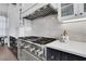 Modern kitchen with stainless steel gas range, white marble backsplash, and custom cabinetry at 13 Highland Park Ne Ln, Atlanta, GA 30306