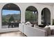 Bright living room with arched windows offering views of the outdoor seating area at 13 Highland Park Ne Ln, Atlanta, GA 30306