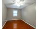 Empty bedroom with hardwood floors, ceiling fan, and window allowing for natural light at 134 Timber Creek Sw Ln, Marietta, GA 30060