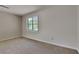 A simple bedroom with neutral carpet and a bright window at 1704 Yarborough Dr, Peachtree City, GA 30269