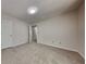 A carpeted bedroom with neutral finishes features an open doorway and ample space at 1704 Yarborough Dr, Peachtree City, GA 30269