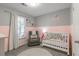 Cozy Bedroom with a two-tone paint scheme, gray chair, and white crib at 2038 Summertown Dr, Norcross, GA 30071
