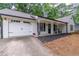 A charming home with a two-car garage, manicured landscaping, rocking chairs, and black shutters at 2038 Summertown Dr, Norcross, GA 30071