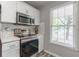 Modern kitchen features stainless steel appliances, white subway tile backsplash, and natural light at 2038 Summertown Dr, Norcross, GA 30071