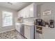 Bright kitchen features white cabinets, stainless steel appliances, and a window overlooking the yard at 2038 Summertown Dr, Norcross, GA 30071