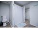 Bathroom with a toilet, shower curtain, and wood-look flooring, adjacent to a walk-in closet at 300 Old Boy Scout Rd, Whitesburg, GA 30185