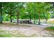Exterior view of the home featuring mature trees, a deck, and a tranquil pond in the background at 300 Old Boy Scout Rd, Whitesburg, GA 30185