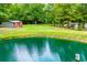 A view of the property with mature trees, and outbuildings surrounding one of several ponds at 300 Old Boy Scout Rd, Whitesburg, GA 30185