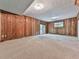 Large basement area with wood paneling, carpet flooring, and sliding glass door access at 3771 Club Nw Dr, Kennesaw, GA 30144