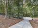 Long concrete driveway leading to a charming home surrounded by lush greenery and mature trees at 3771 Club Nw Dr, Kennesaw, GA 30144